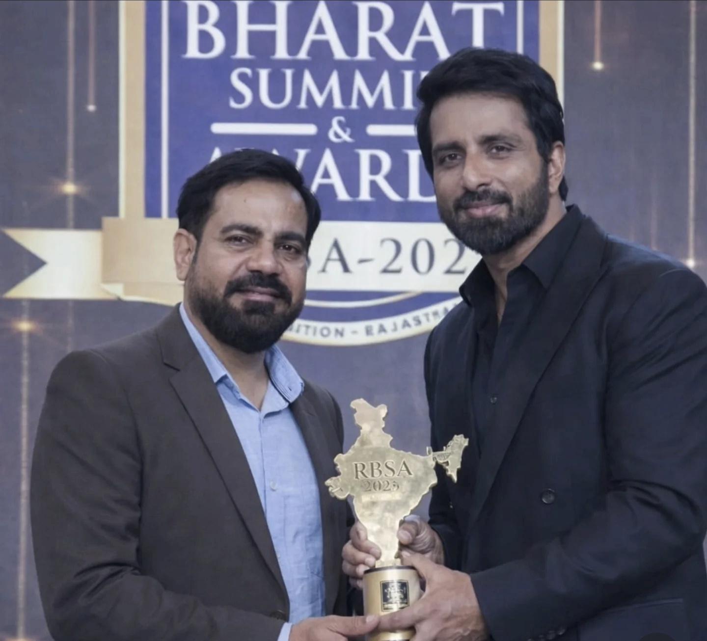 Astrologer standing beside a guest while holding an RBSA 2023 award